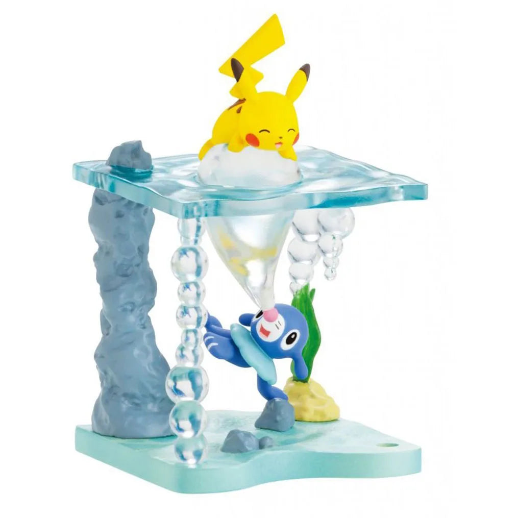 Lot de mini-figurines Pokémon variées présentées sur de petits socles thématiques d'environnement aquatique.
