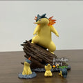 Statuette Pokémon représentant Typhlosion et Héricendre en plein combat, présentés sur un socle thématique d'environnement naturel nocturne.
